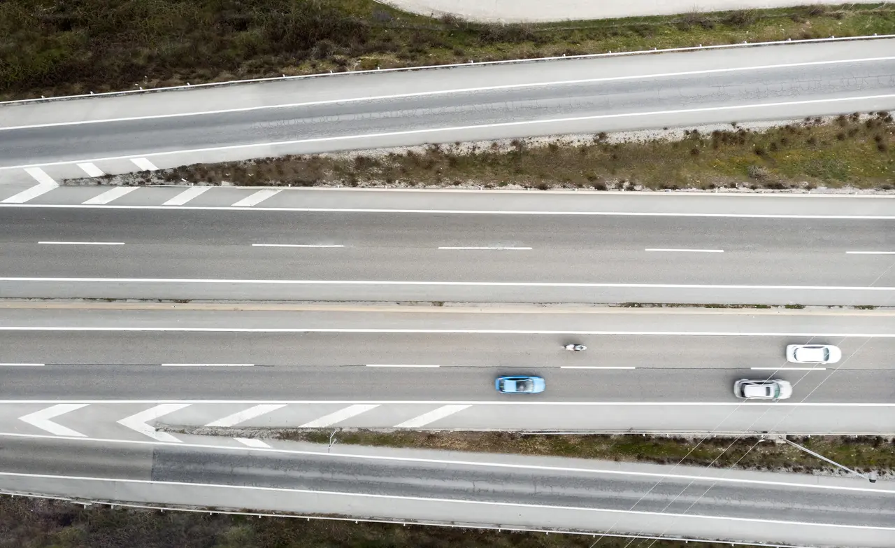 Three roads of different widths merging into a single road
